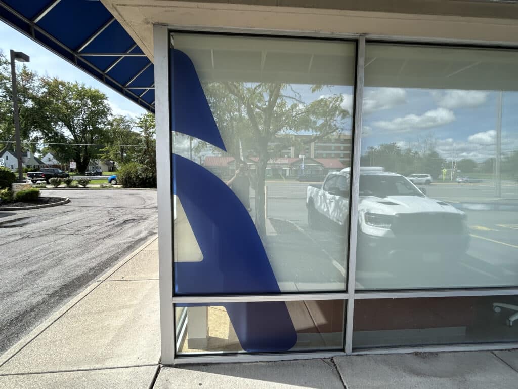 Close-up of the large, reflective glass windows on the side of an Aspen Dental facility.