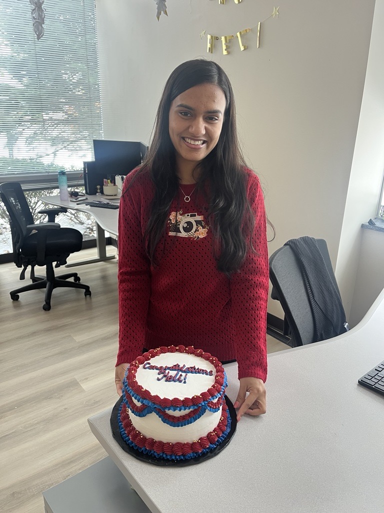 Heli Patel with a red, white and blue cake that says "Congratulations, Heli!"