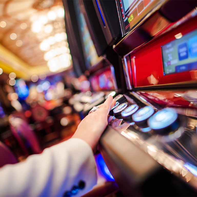 Casino Slot Video Games. Woman Playing Video Slot in the Casino. Hand on Betting Button Closeup Photo.